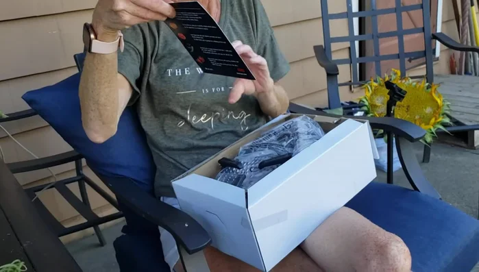 Person unpacking food mill with instructions.