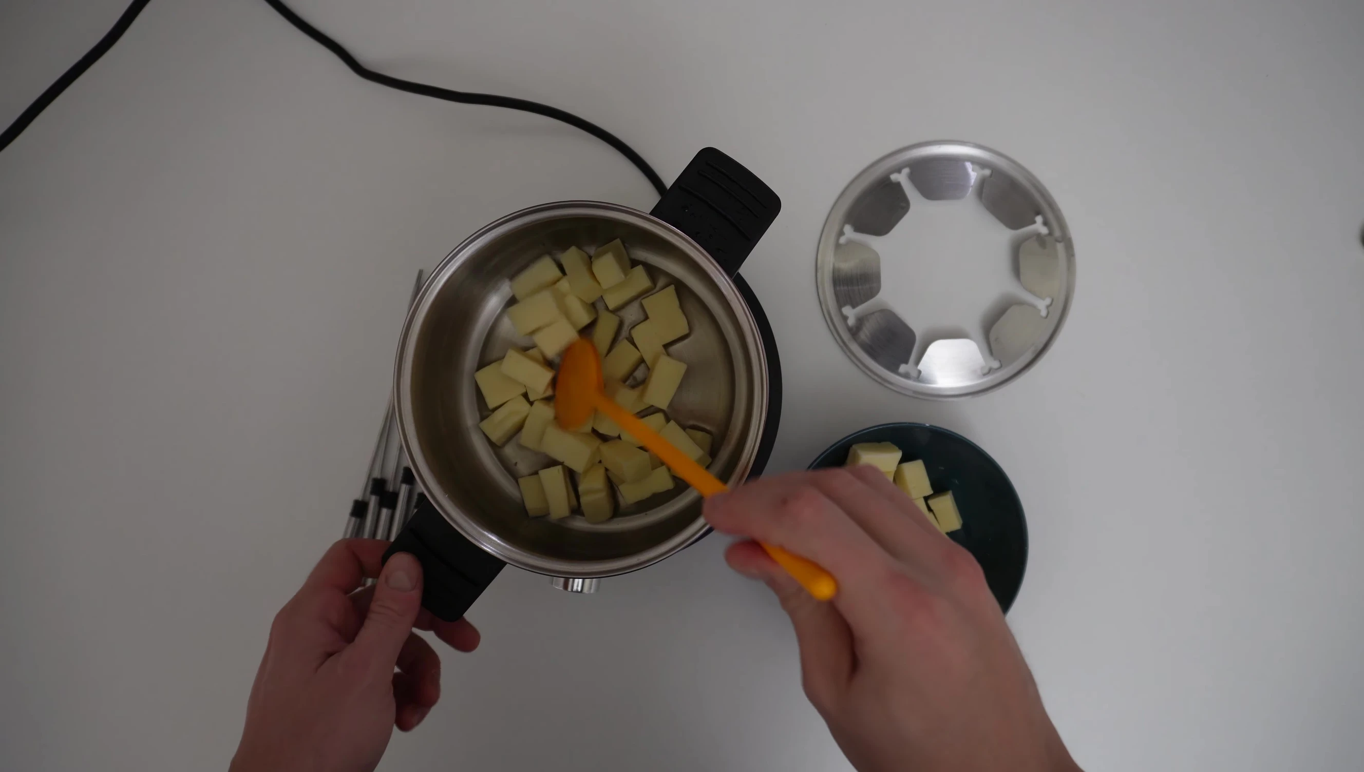 Cheese cubes melting in electric fondue pot
