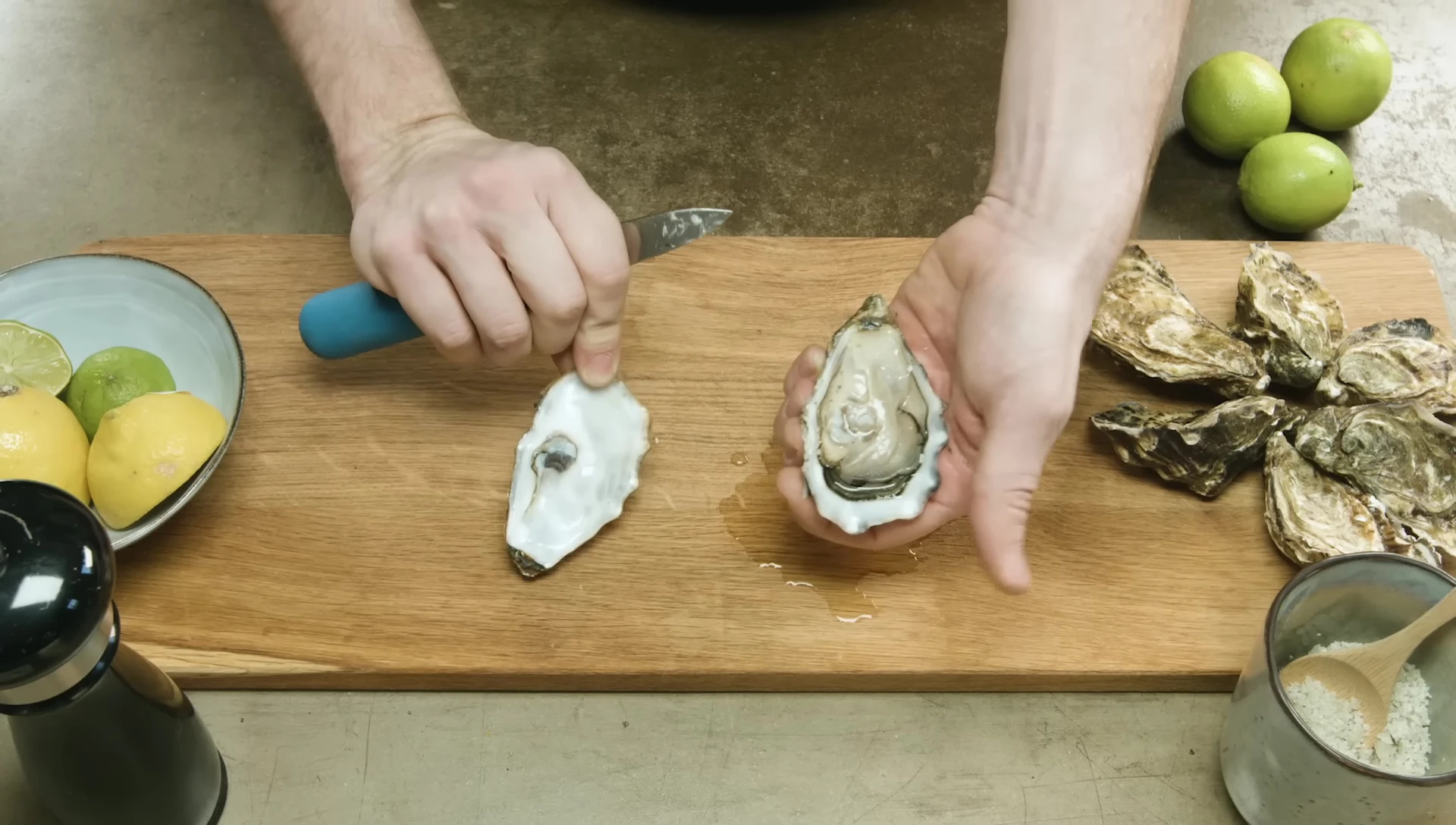 Opening oyster with knife, lemon, and pepper.