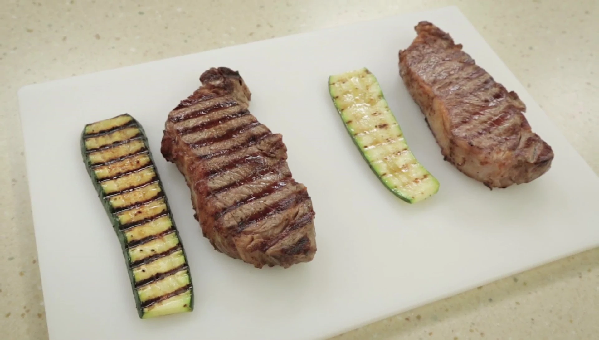 Grilled steak and zucchini on cutting board