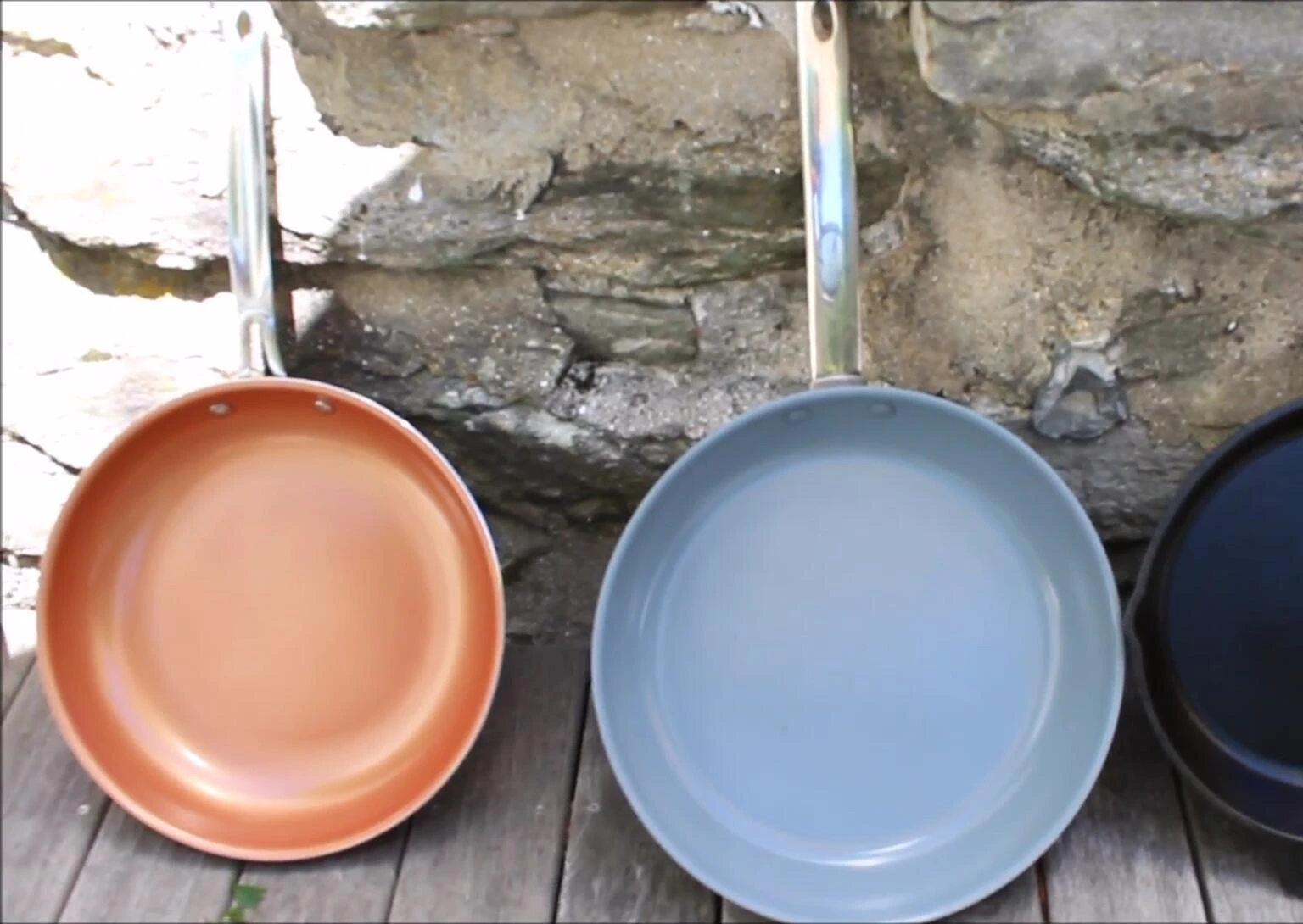 Vue d'ensemble des quatre poêles: fonte, verte, cuivre rouge et inox.