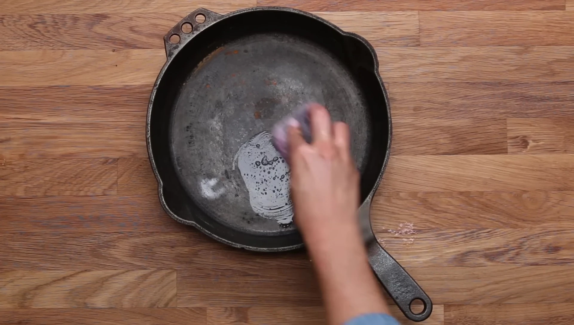 Nettoyage de la poêle en fonte avec de la laine d'acier.