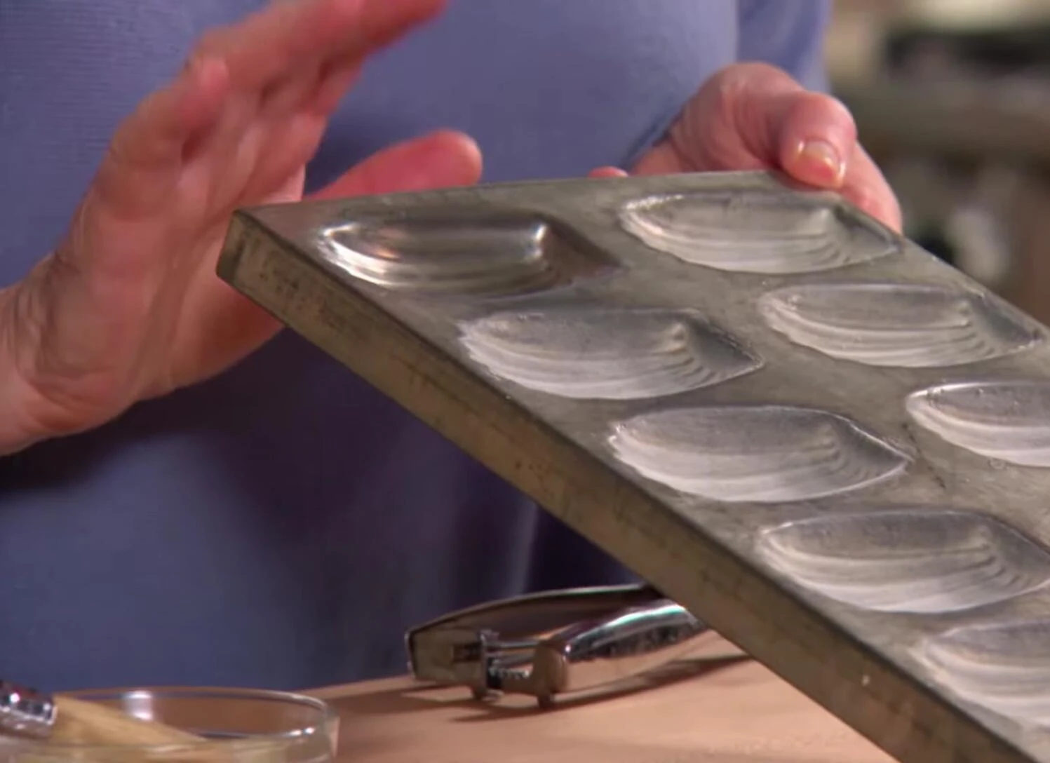 Gros plan sur les moules à madeleines en métal.