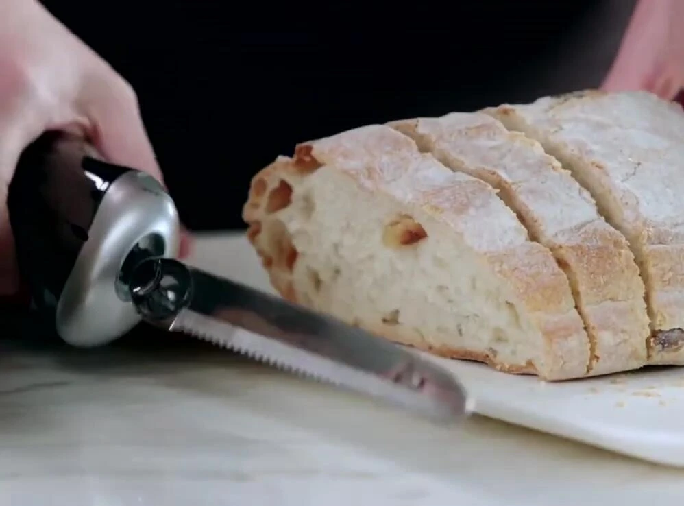 Vue générale du couteau en action sur une planche à découper.